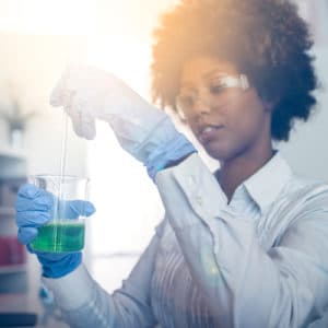 Chemist performing lab experiment with beaker