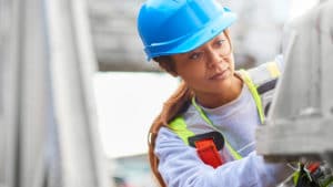 Civil Engineering College Major - Woman on construction site wearing blue hard hat and evaluating a concrete test