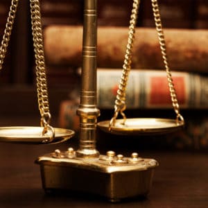 Law & Public Safety Career Cluster image with brass scales in front of a stack of old legal books