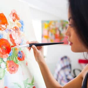 Artist painting flowers on a canvas