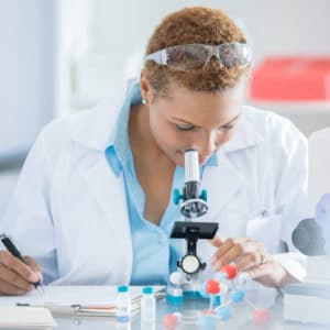Microbiologist examines molecules with a microscope in laboratory