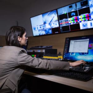 Broadcast Engineer working at audio mixer and computer