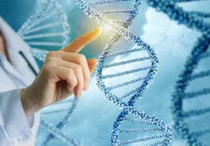 Woman in white lab coat pointing at a section of double helix DNA model