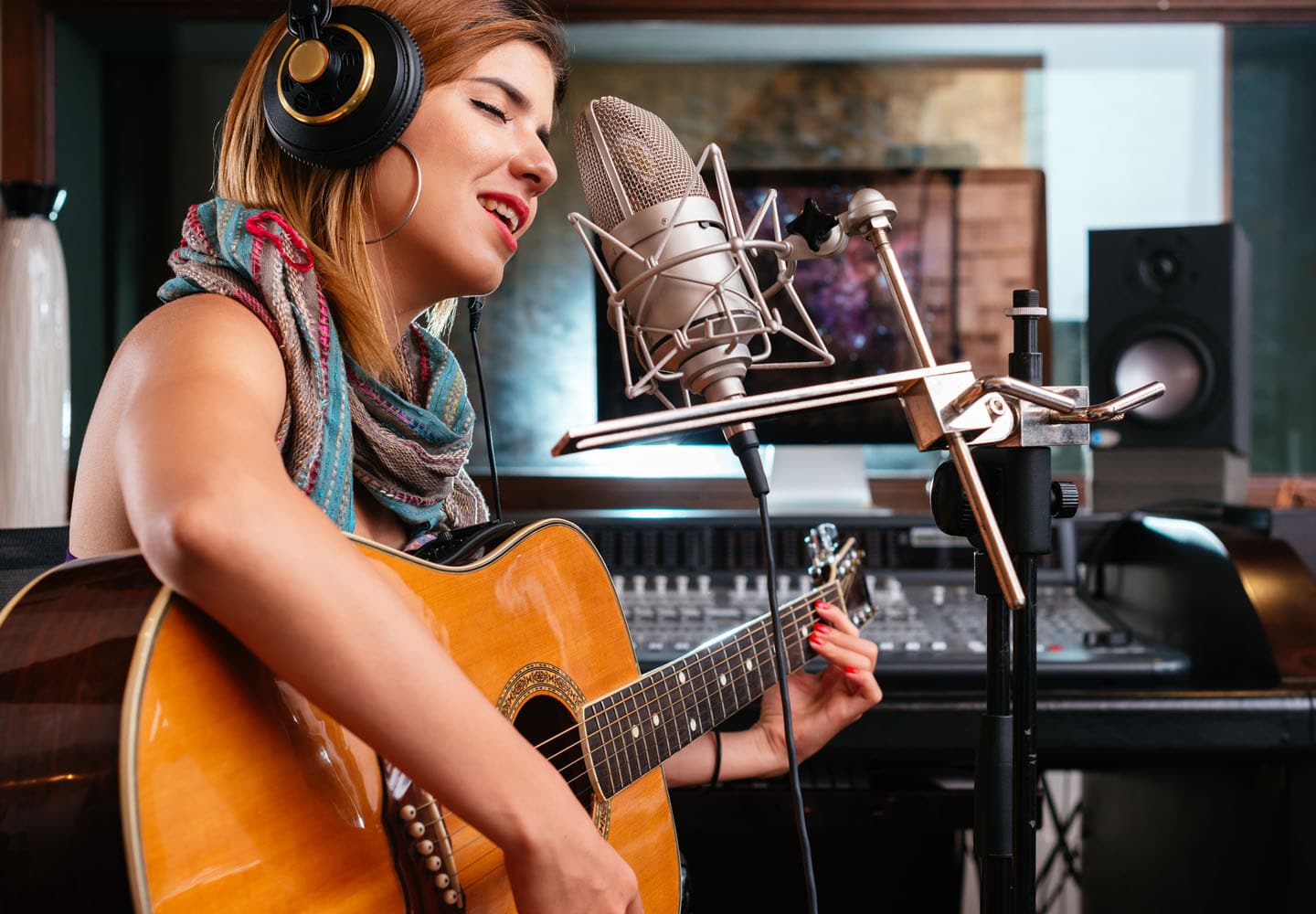 Music major playing the guitar in a recording studio