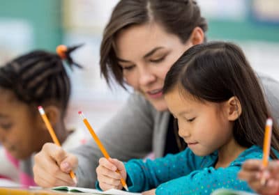Teacher assisting student in class