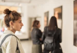 Art History and Curation Major - Woman studying a painting on the wall