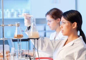 Biochemistry College Major - Two women scientists in a laboratory mixing liquids in glass beakers