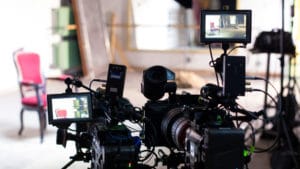 Camera operator career professional set up on a video production shoot in a living room with an antique red chair