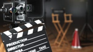 Producer and director film production set with slate board, movie film camera, chair and red and silver megaphone