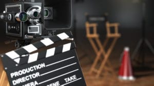 Producer and director film production set with slate board, movie film camera, chair and red and silver megaphone