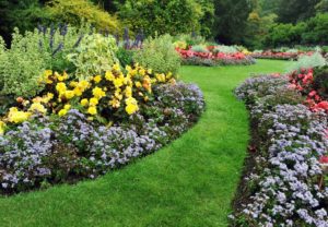 Landscaped grounds with green grass and colorful flowerbeds