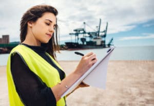 Marine engineering major on beach with ship in background