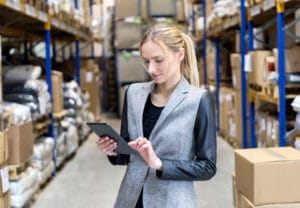 Supply chain management major checking clipboard in warehouse