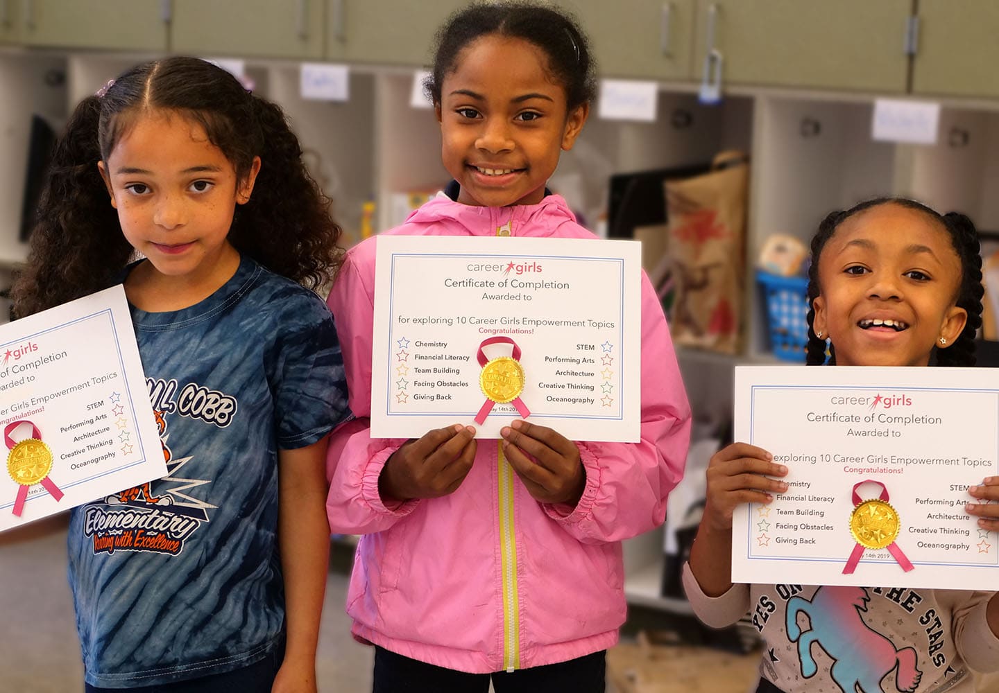 Three smiling girls holding certificate from Career Girls
