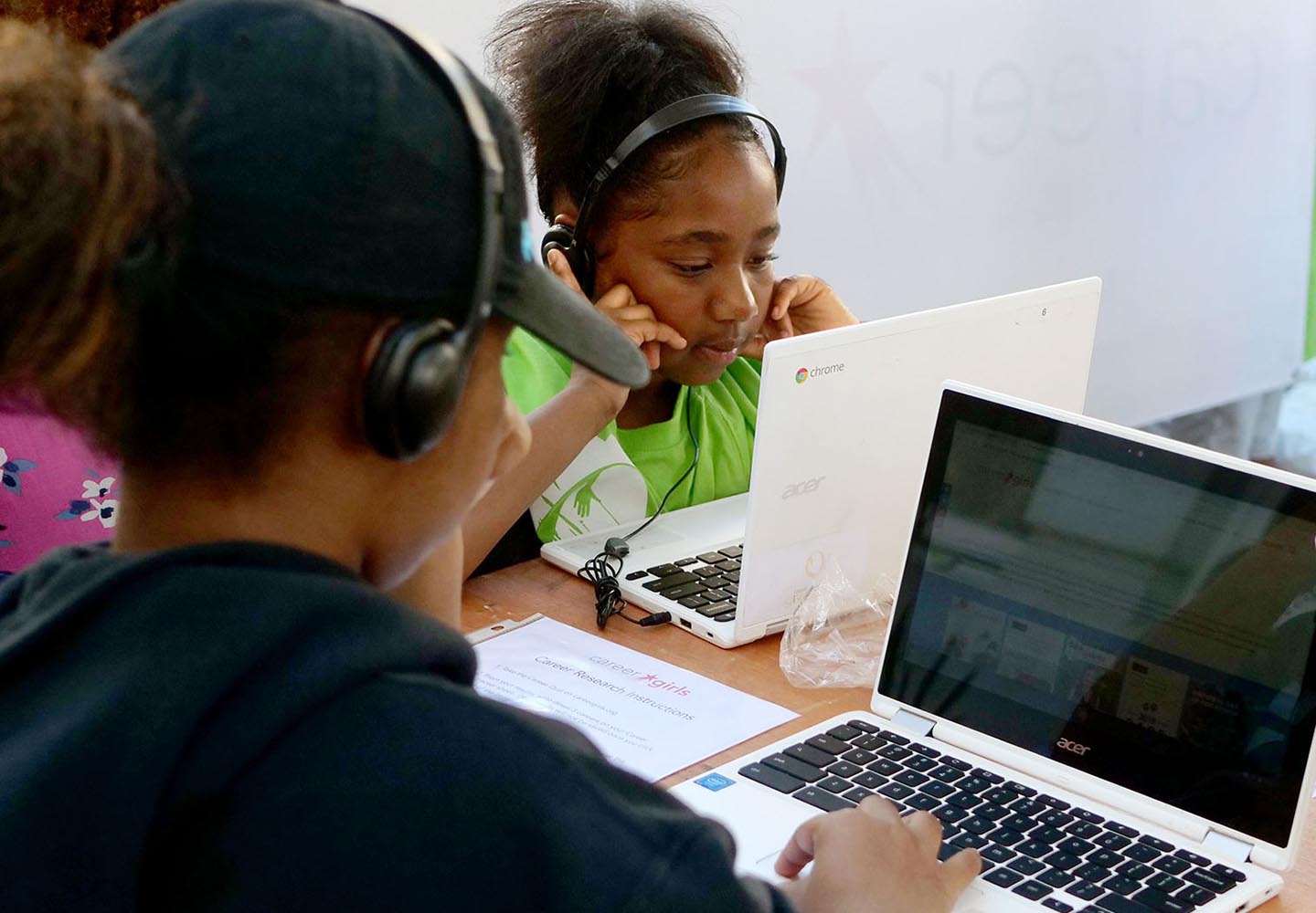 two girls with laptops