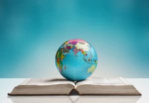 Round globe sitting on top of an open world atlas