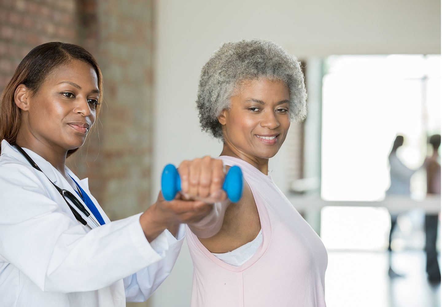 Physical therapist helps senior woman with wrist injury