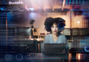 Software engineer works on developing code at laptop in office