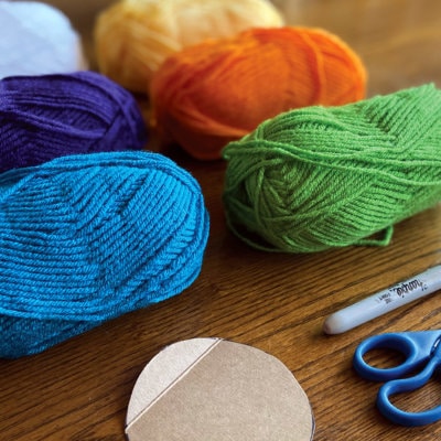 Friendship Bracelet materials brightly colored yarn scissors cardboard and sharpie