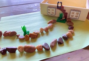 Two rows of pebble landscaping in front of model house