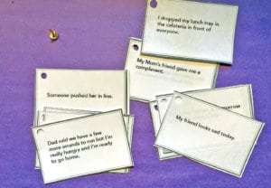 Empathy cards spread out over a purple paper background with messages to inspire conversations to develop empathetic students