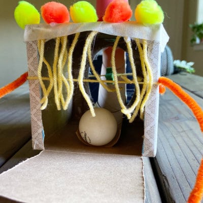 Exit final end ping pong ball going through cardboard tube at top of obstacle course activity