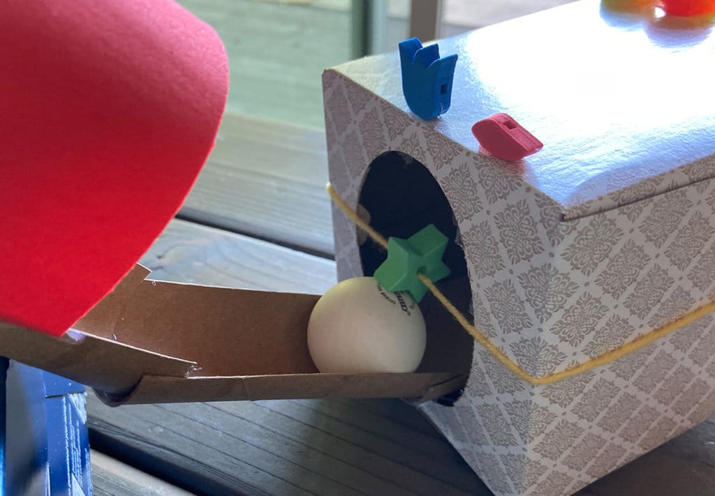 Nearing the end ping pong ball going through cardboard tube at top of obstacle course activity