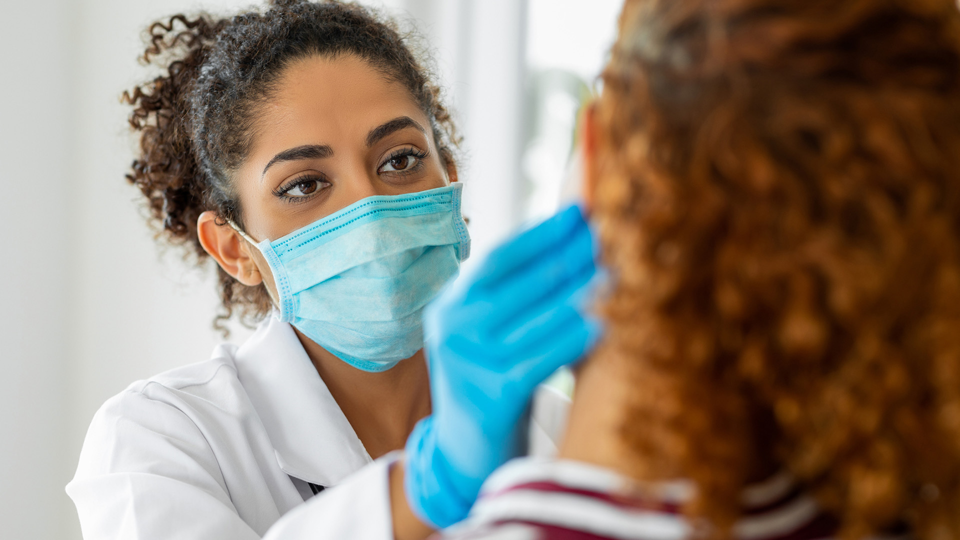 Dentist career - female dentist examines patient in dental chair