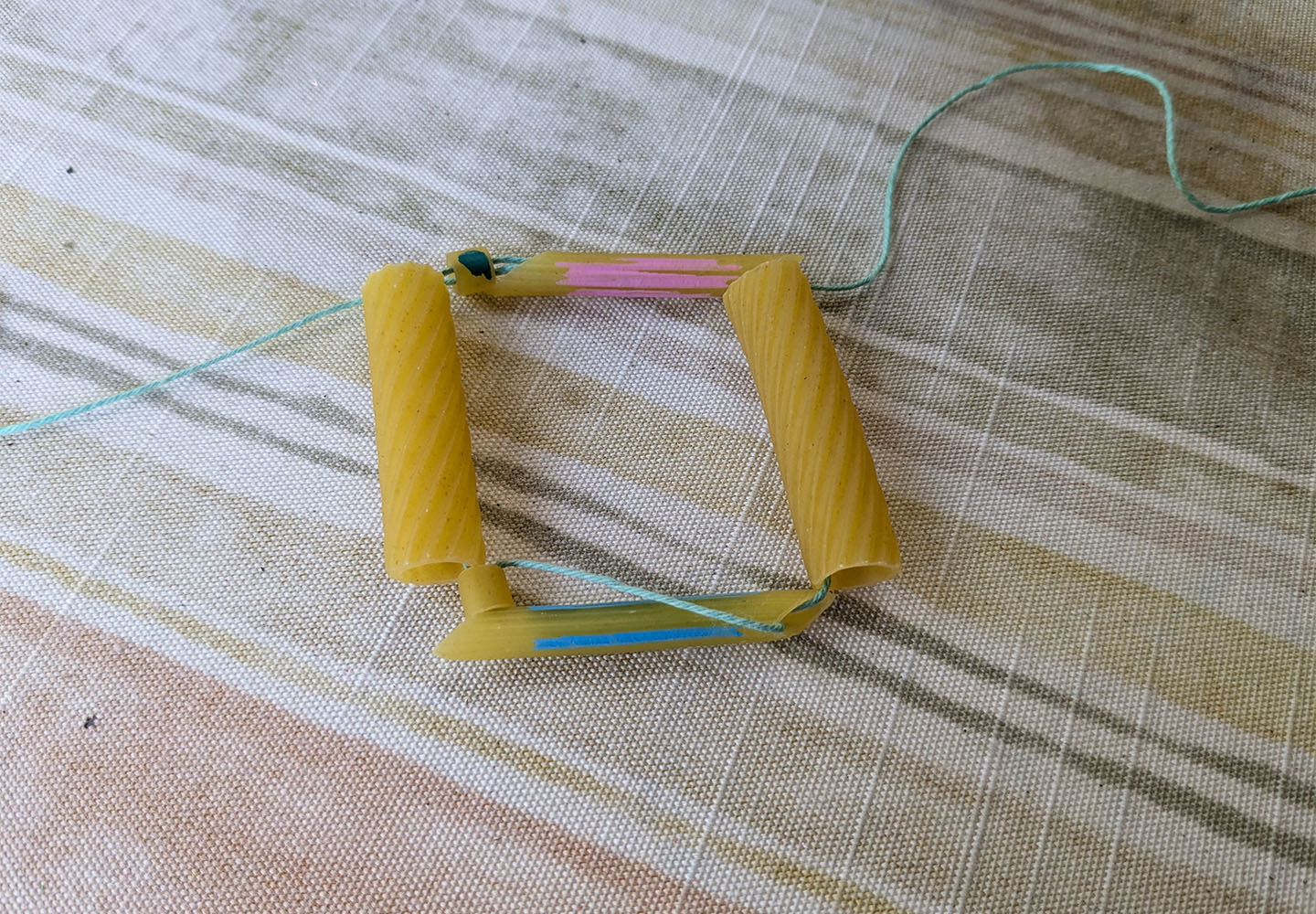Genetics Empowerment Video Group Activity - Genetics DNA Model From Pasta - string the group and then string through both pasta pieces the other way